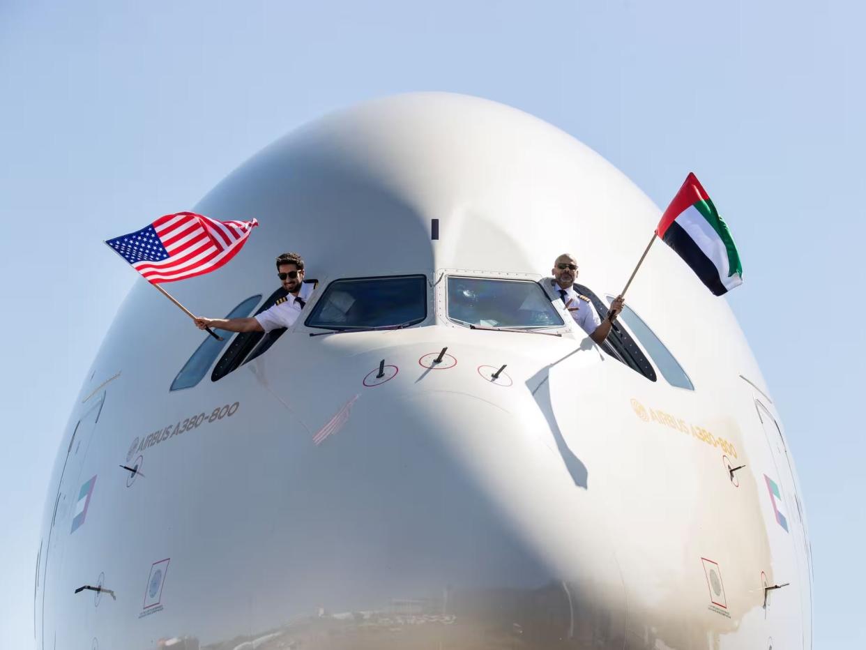 Etihad pilots hand out the windows of the A380 with the US and UAE flags.