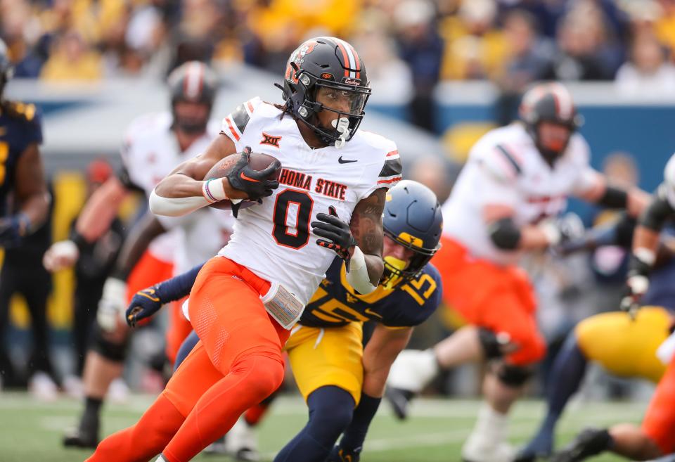 Oklahoma State running back Ollie Gordon II (0) runs for a touchdown during the first quarter against West Virginia on Saturday at Mountaineer Field at Milan Puskar Stadium.