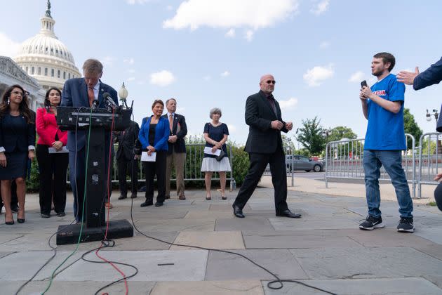 Rep. Paul Gosar (left, at the podium) reacts as a protester calls out to him Wednesday during a news conference about the World Health Organization. Gosar continued speaking. Rep. Clay Higgins is second from right.