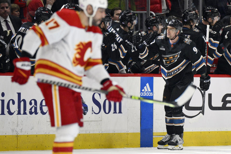 Washington Capitals center Evgeny Kuznetsov (92) celebrates his goal as Calgary Flames left wing Milan Lucic (17) skates away during the second period of an NHL hockey game, Friday, Nov. 25, 2022, in Washington. (AP Photo/Nick Wass)