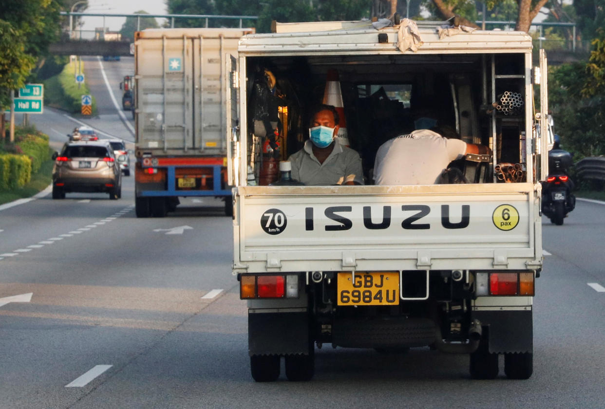 Migrant workers sit in the back of a lorry, amid the COVID-19 outbreak here on 15 May, 2020. (PHOTO: Reuters)