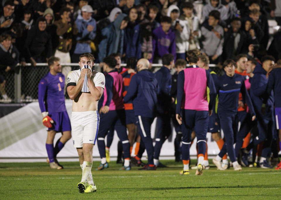 Creighton's Duncan McGuire walks off the pitch as Syracuse celebrates the win in an NCAA men's soccer tournament semifinal in Cary, N.C., Friday, Dec. 9, 2022. (AP Photo/Ben McKeown)