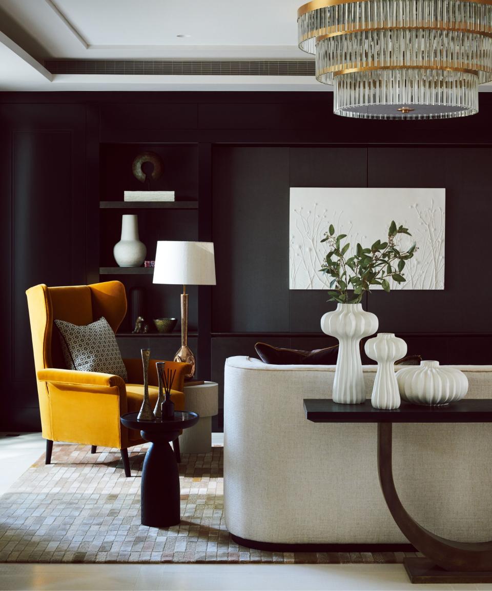 Black walls and table, yellow chair, white vases