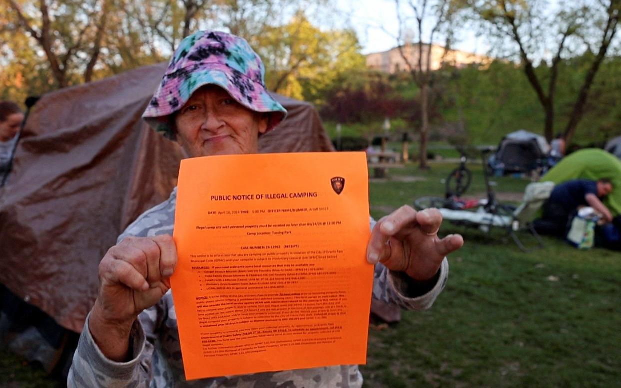 Homeless woman holds police notice