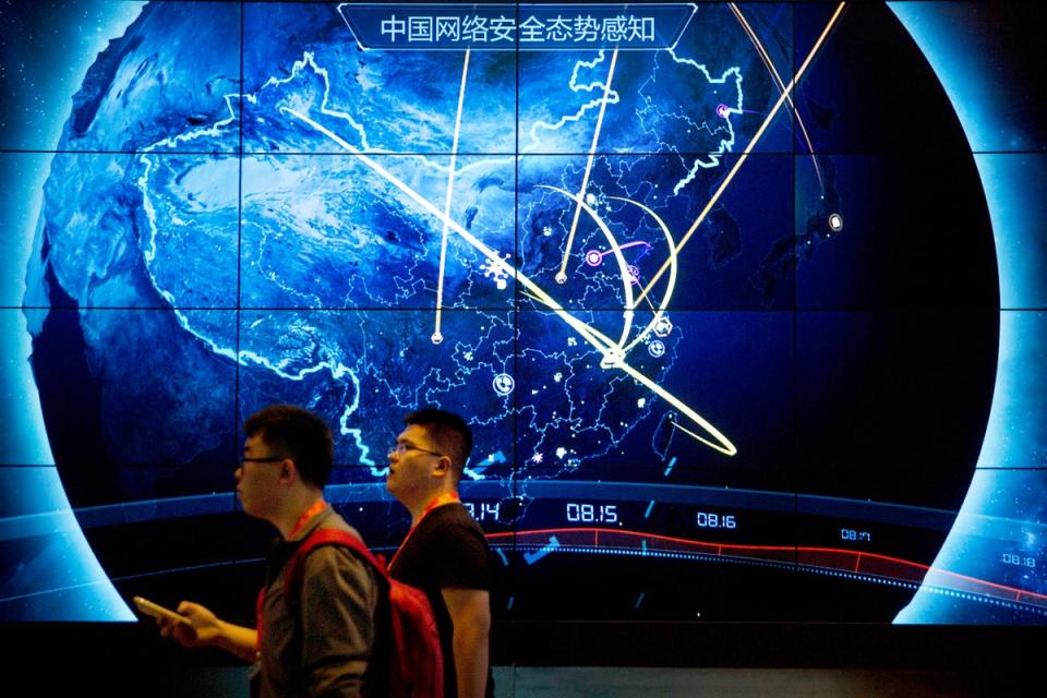 Attendees at a Chinese internet safety conference walk past an electronic display showing recent cyberattacks in China (AP)