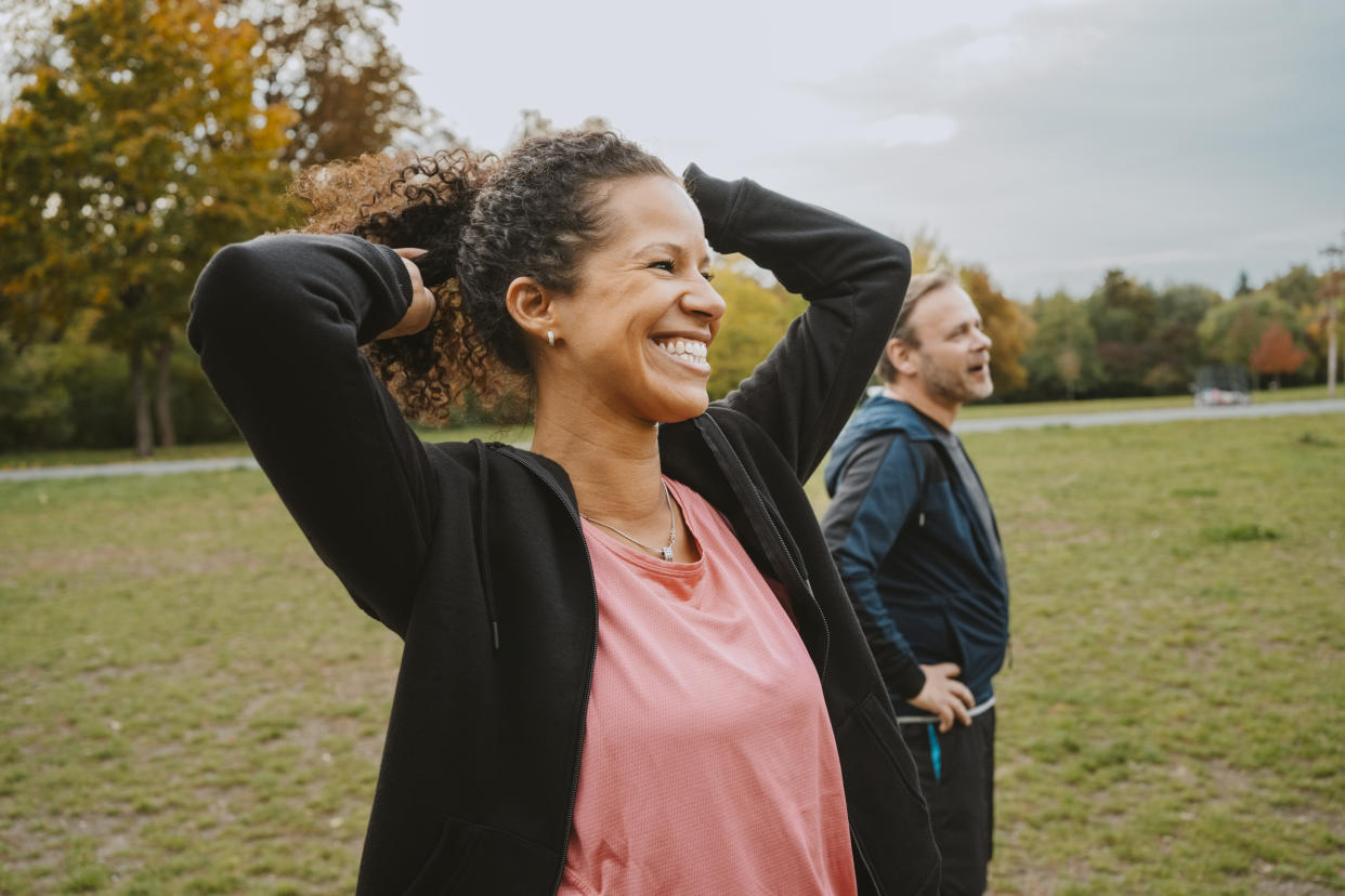 woman smiling outside next to a man