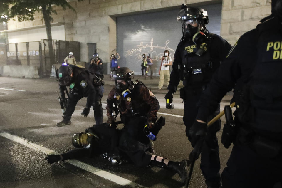 FILE - In this July 29, 2020, file photo, federal agents arrest a demonstrator during a Black Lives Matter protest at the Mark O. Hatfield United States Courthouse in Portland, Ore. An Associated Press analysis of more than 200 arrests shows that even those accused of breaking the law during the nightly rallies don’t neatly fit into President Donald Trump’s depiction of protesters as “anarchists and agitators.” (AP Photo/Marcio Jose Sanchez, File)