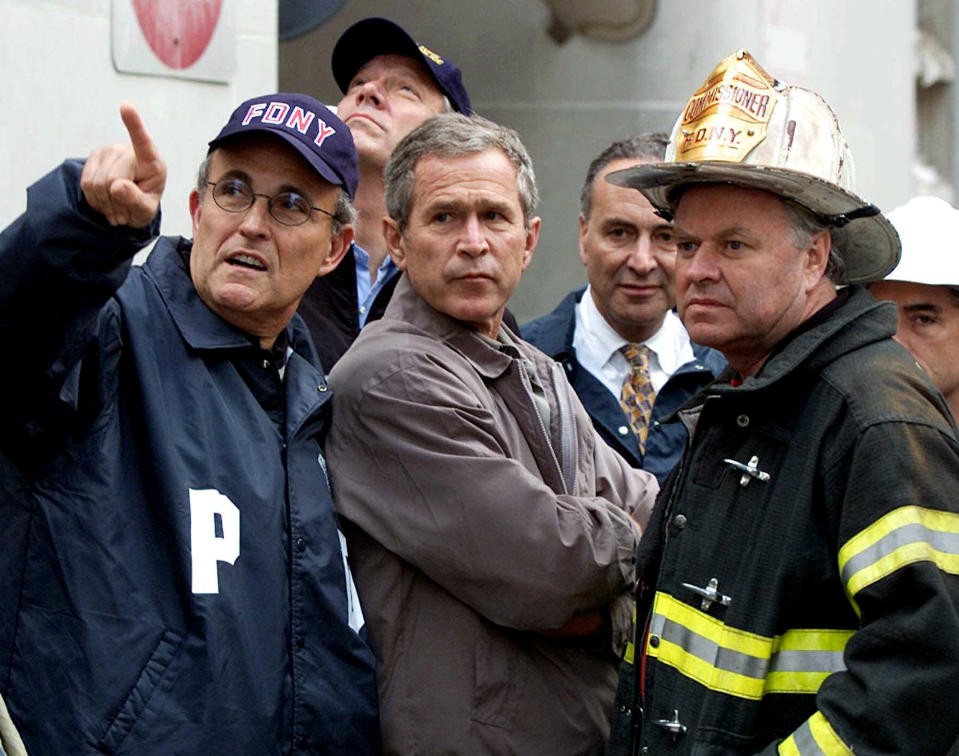 President George W. Bush, center, with, from left, former New York City Mayor Rudolph Giuliani, then-New York Gov. George Pataki, Sen. Charles Schumer, D-N.Y., and former New York City Fire Commissioner Thomas Van Essen look toward the fallen buildings during a tour of the World Trade Center in New York on Sept. 14, 2001. (Doug Mills/AP)