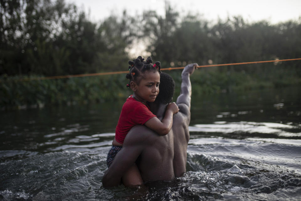 Haitian migrants wade across the Rio Grande from Del Rio, Texas, to return to Ciudad Acuña, Mexico, Sunday, Sept. 19, 2021, to avoid deportation to Haiti from the U.S. The U.S. is flying Haitians camped in a Texas border town back to their homeland and blocking others from crossing the border from Mexico in a massive show of force that signals the beginning of what could be one of America's swiftest, large-scale expulsions of migrants or refugees in decades. (AP Photo/Felix Marquez)
