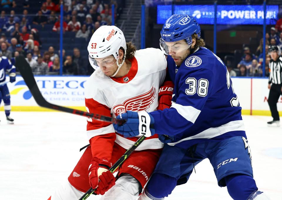 Red Wings defenseman Moritz Seider and Lightning left wing Brandon Hagel fight to control the puck during the first period on Tuesday, Dec. 6, 2022, in Tampa, Florida.