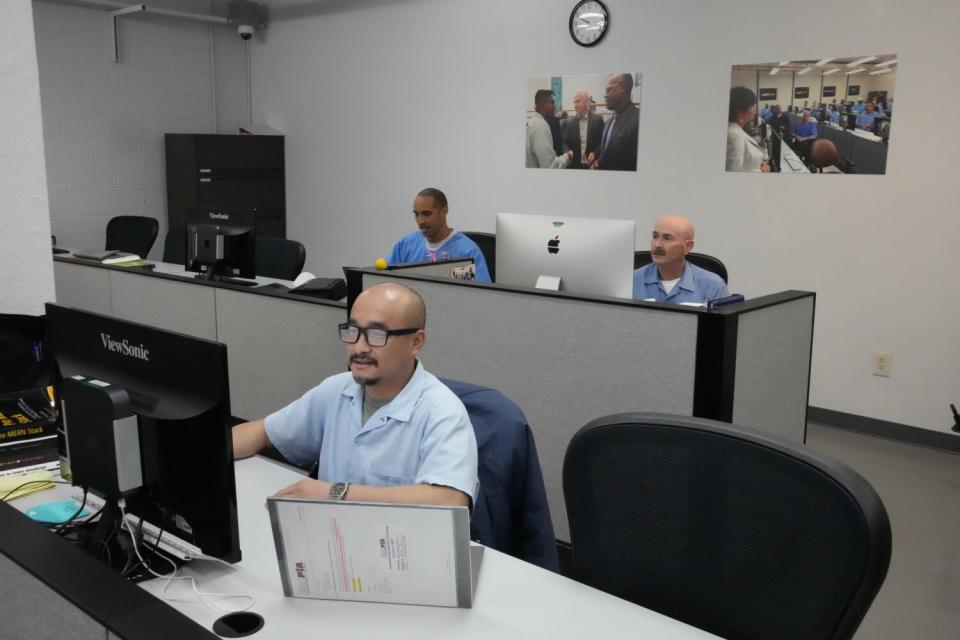 Incarcerated men work at computers