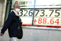 A person walks past an electronic stock board showing Japan's Nikkei 225 index at a securities firm Tuesday, Nov. 14, 2023, in Tokyo. Asian shares were mostly higher Tuesday ahead of potentially market-moving developments, including a U.S.-China summit and data releases from the U.S., Japan and China. (AP Photo/Eugene Hoshiko)