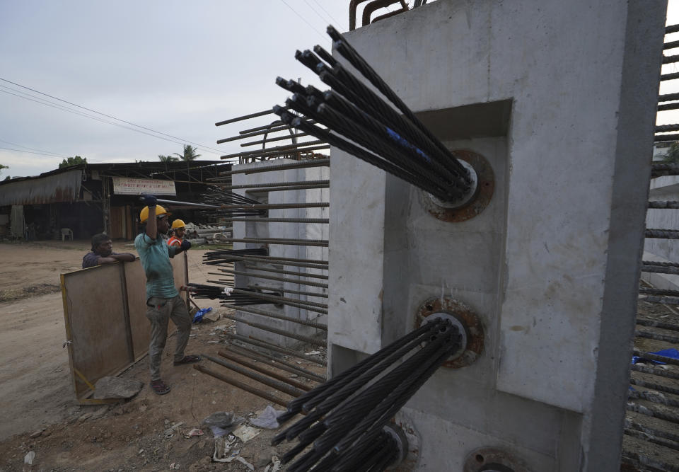 Laborers work on the construction of a flyover bridge in Hyderabad, India, Wednesday, Aug. 31, 2022. India’s economy grew by 13.5% in the April-June quarter from a year earlier, pushed up by a boost in agriculture and manufacturing as pandemic curbs eased, official figures released Wednesday show. (AP Photo/Mahesh Kumar A.)