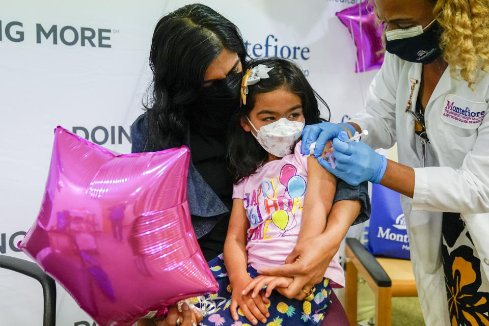 Shivani Agarwal, left, holds her daughter Kiran, 3, as Registered Nurse Margie Rodriguez administers the first dose of the Moderna COVID-19 vaccine for children 6 months through 4 years old, Tuesday, June 21, 2022, at Montefiore Medical Group in the Bronx borough of New York. / Credit: Mary Altaffer / AP