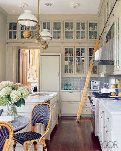 <p>Just a few hints of blue are enough to brighten this kitchen at Oakley Farm, a 19th-century manor in northern Virginia. Decorator <a rel="nofollow noopener" href="http://www.katieridder.com" target="_blank" data-ylk="slk:Katie Ridder;elm:context_link;itc:0;sec:content-canvas" class="link ">Katie Ridder</a> and architect <a rel="nofollow noopener" href="http://www.ppapc.com/" target="_blank" data-ylk="slk:Peter Pennoyer;elm:context_link;itc:0;sec:content-canvas" class="link ">Peter Pennoyer</a> designed kitchen cabinets that extend to the ceiling to take advantage of often-wasted space, and added bursts of blue color in the wicker chairs, backsplash and fruit stand. </p>