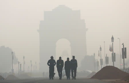 Men walk in front of the India Gate shrouded in smog in New Delhi, India, December 26, 2018. REUTERS/Adnan Abidi