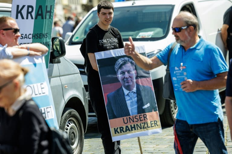Un partidario del partido de extrema derecha Alternativa para Alemania (AfD) muestra un cartel en que se lee "Unser Krahnzler", un juego de palabras para decir Krah "nuestro canciller", el 1 de mayo de 2024 en un acto electoral en Dresde (Jens Schlueter)