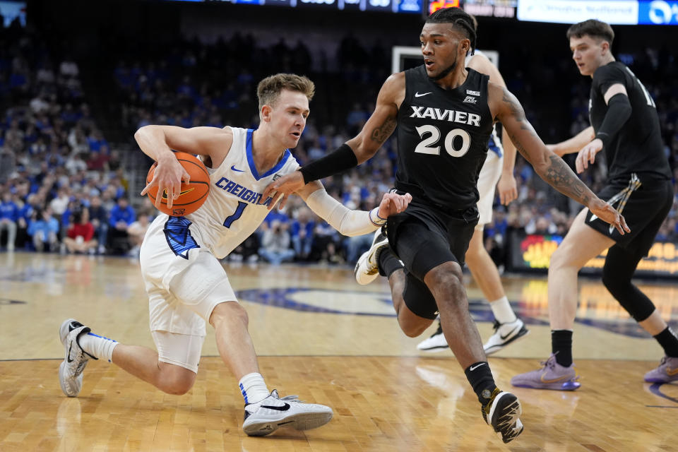 Creighton guard Steven Ashworth (1) drives past Xavier guard Dayvion McKnight (20) during the first half of an NCAA college basketball game, Tuesday, Jan. 23, 2024, in Omaha, Neb. (AP Photo/Charlie Neibergall)