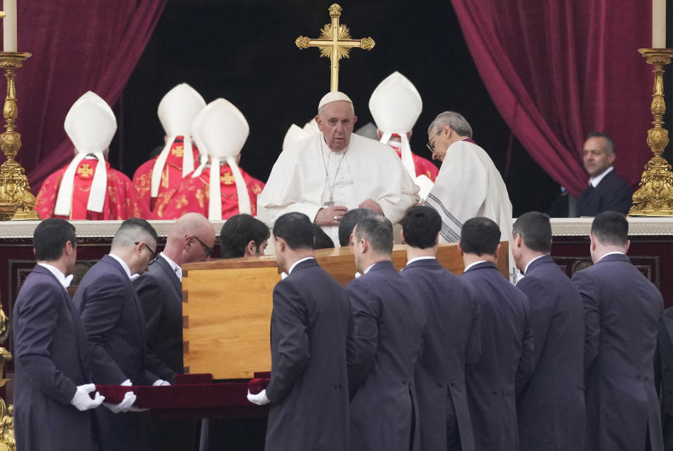 Pope Francis, centre, sits as the coffin of late Pope Emeritus Benedict XVI St. Peter's Square is carrying for a funeral mass at the Vatican, Thursday, Jan. 5, 2023. Benedict died at 95 on Dec. 31 in the monastery on the Vatican grounds where he had spent nearly all of his decade in retirement. (AP Photo/Alessandra Tarantino)