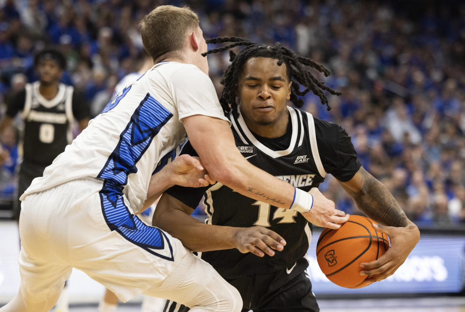 Creighton's Baylor Scheierman, left, reaches to knock the ball away from Providence's Corey Floyd Jr. during the first half of an NCAA college basketball game Saturday, Jan. 6, 2024, in Omaha, Neb. (AP Photo/Rebecca S. Gratz)