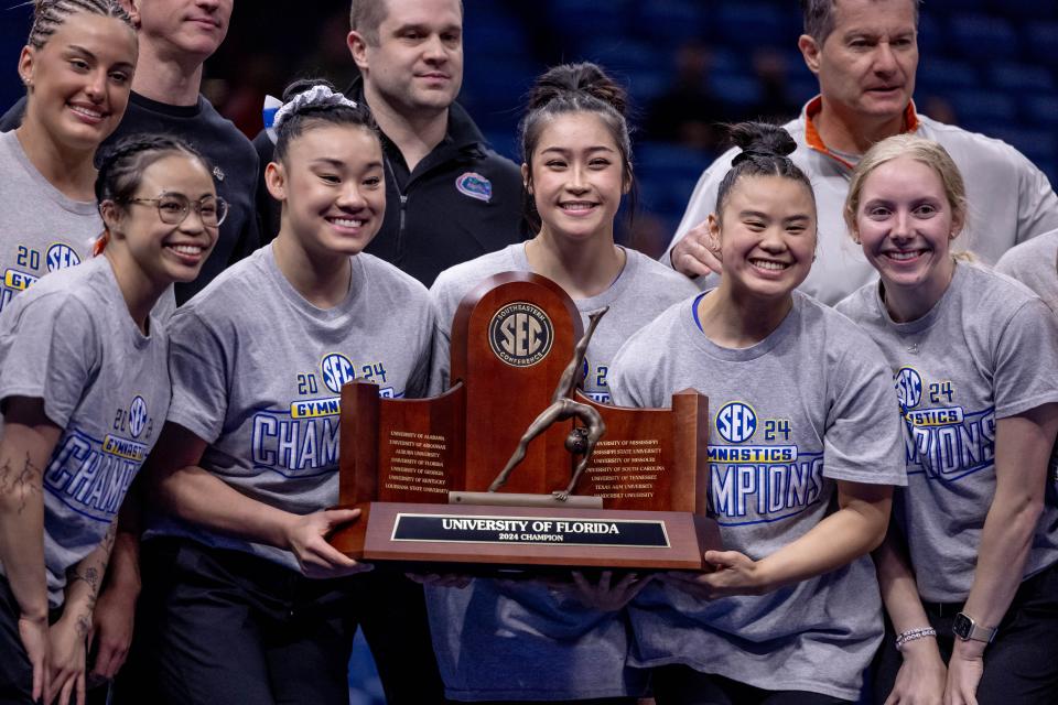 Mar 23, 2024; New Orleans, LA, USA; Florida Gators accepting the 2024 regular season SEC title trophy during the SEC Gymnastics Championship at Smoothie King Center. Mandatory Credit: Stephen Lew-USA TODAY Sports