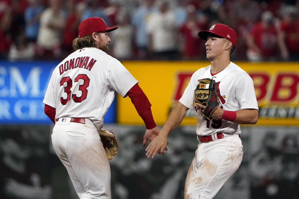 St. Louis Cardinals' Brendan Donovan (33) and Tommy Edman celebrate a 7-3 victory over the Cincinnati Reds following a baseball game Friday, July 15, 2022, in St. Louis. (AP Photo/Jeff Roberson)