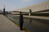 In this Feb. 11, 2014 photo, a visitor stands near sculptures at Nanjing Massacre Memorial Hall in Nanjing, in eastern China's Jiangsu province. The Tokyo shrine and the memorial hall in Nanjing, as Nanking is now called, are physical embodiments of divergent views of history that still strain China-Japan relations, 70 years after the war. They complicate America's objective of maintaining peace and stability in the Pacific, as President Barack Obama starts a 4-country Asian tour in Japan this week. The implications are potentially serious, particularly over contested uninhabited islands called the Senkaku by Japan and Diaoyu by China. (AP Photo/Alexander F. Yuan)