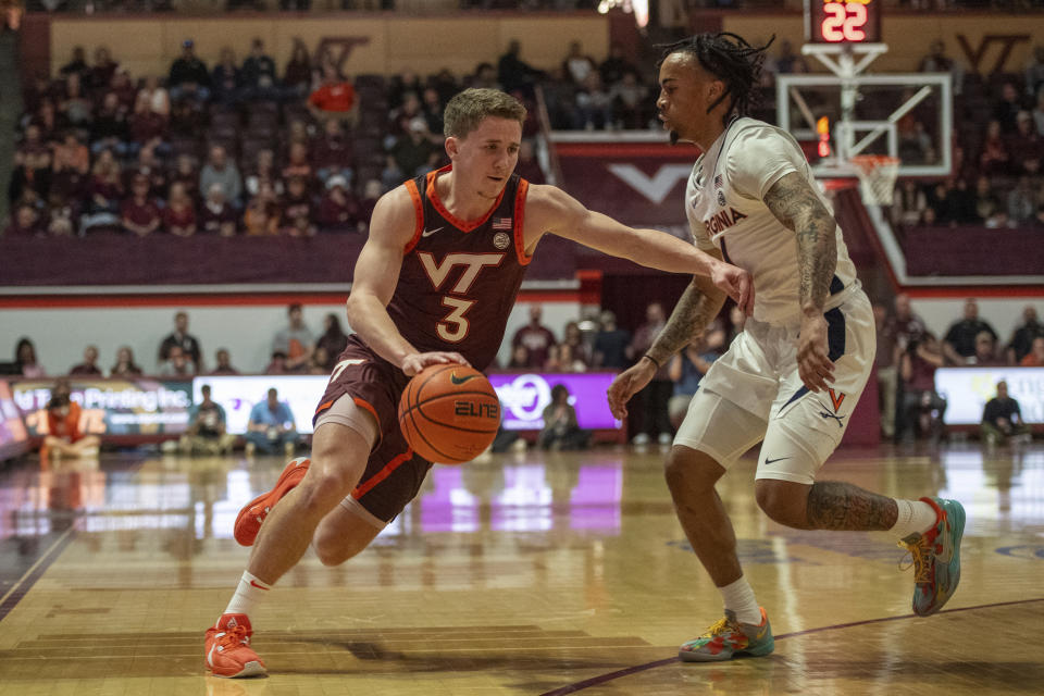 Virginia Tech's Sean Pedulla drives by Virginia's Dante Harris during the first half of an NCAA college basketball game, Monday, Feb. 19, 2024, in Blacksburg, Va. (AP Photo/Robert Simmons)