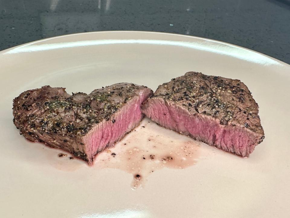 Steak that was made in the air fryer, cut in half.