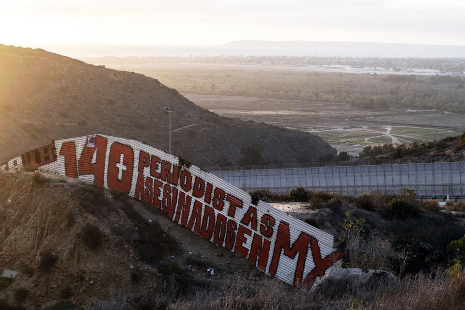 A painting reading in Spanish "140 periodistas asesinado en MX" (140 journalists murderedin MX) is seen at a US/Mexico border fence section in Tijuana, Baja California State, Mexico, on May 14, 2018. - The painting was made by foreign and local journalists, who did not want to be identified, to denounce the murders of journalists in Mexico and to raise awareness on the dangerous situation lived by journalists in the country. May 15th is the first anniversary of the murder of Mexican journalist and AFP contributor Javier Valdez, who was killed in Culiacan, Sinaloa State. (Photo by GUILLERMO ARIAS / AFP)        (Photo credit should read GUILLERMO ARIAS/AFP via Getty Images)