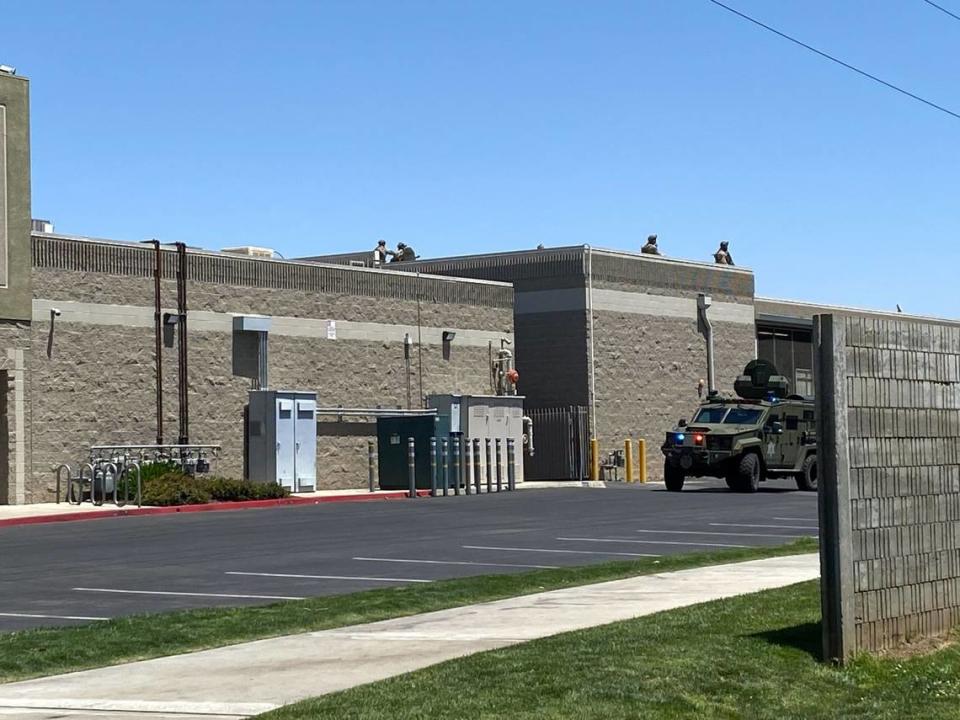 A law enforcement vehicle on Friday, May 20, 2022 is parked near the rear of the Save Mart grocery store where a suspect barricaded himself inside Thursday night in Fresno, California.