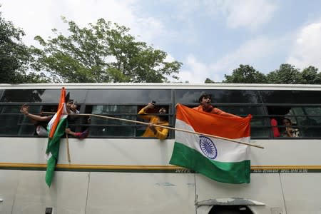 People shout slogans from a police bus after being detained while celebrating the scrapping of special constitutional status for Kashmir by the government, in New Delhi
