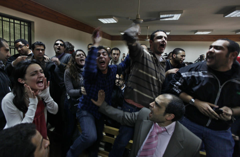 FILE - In this Sunday, Feb. 26, 2012 file photo, Egyptian protesters chant anti-military ruling slogans during a trial of employees of pro-democracy groups charged with using foreign funds to foment unrest in Cairo, Egypt. Egypt has lifted a travel ban on Wednesday, Feb. 29 for seven Americans charged with fomenting unrest by working for illegally funded pro-democracy groups, signaling an end to the worst crisis in Egypt-U.S. relations in 30 years. (AP Photo/Khalil Hamra, File)