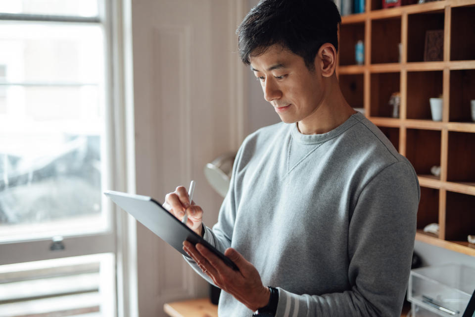 Close up of young male Asian freelancer is working from home with pen and digital tablet. Artist drawing on digital tablet.