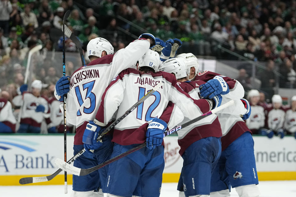 Colorado Avalanche players celebrate a power play goal by Ryan Johansen (12) during the second period of an NHL hockey game against the Dallas Stars, Saturday, Nov. 18, 2023, in Dallas. (AP Photo/Julio Cortez)