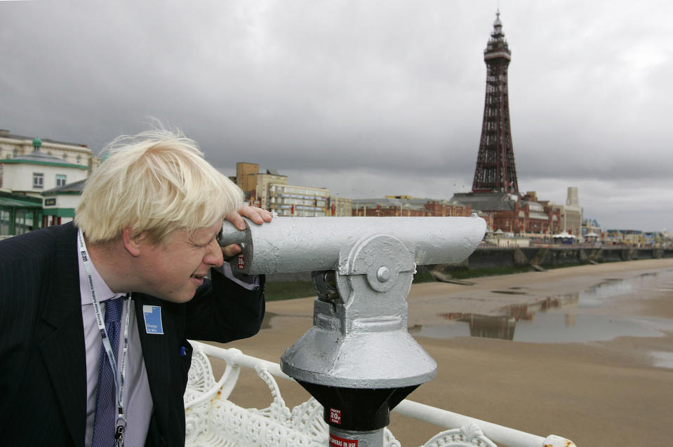 Conservative Party Member of Parliament (MP) Boris Johnson looks through a telescope on Blackpool's north pier during the annual party conference in Blackpool, northern England October 3, 2005. REUTERS/Ian Hodgson