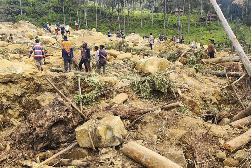 In this image supplied by the International Organization for Migration, villagers search amongst the debris from a landslide in the village of Yambali in the Highlands of Papua New Guinea, Monday, May 27, 2024. (Mohamud Omer/International Organization for Migration via AP)