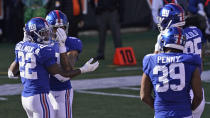 New York Giants running back Wayne Gallman (22) is congratulated by teammates after scoring a touchdown during the first half of an NFL football game against the Cincinnati Bengals, Sunday, Nov. 29, 2020, in Cincinnati. (AP Photo/Bryan Woolston)