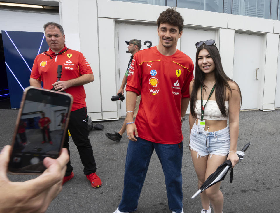 Ferrari driver Charles Leclerc poses for a photo with a fan at the F1 Canadian Grand Prix auto race, Thursday, June 6, 2024 in Montreal. (Ryan Remiorz/The Canadian Press via AP)