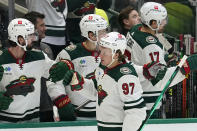 Minnesota Wild left wing Kirill Kaprizov (97) celebrates with teammates on the bench after his goal during the first period of an NHL hockey game against the Dallas Stars in Dallas, Sunday, Dec. 4, 2022. (AP Photo/LM Otero)