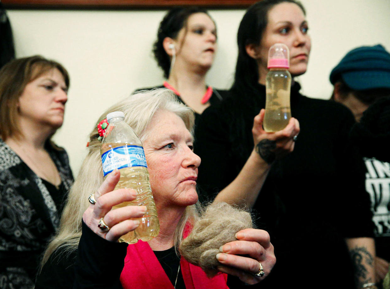 Flint residents hold a bottle full of contaminated water. (Mark Wilson / Getty Images file)