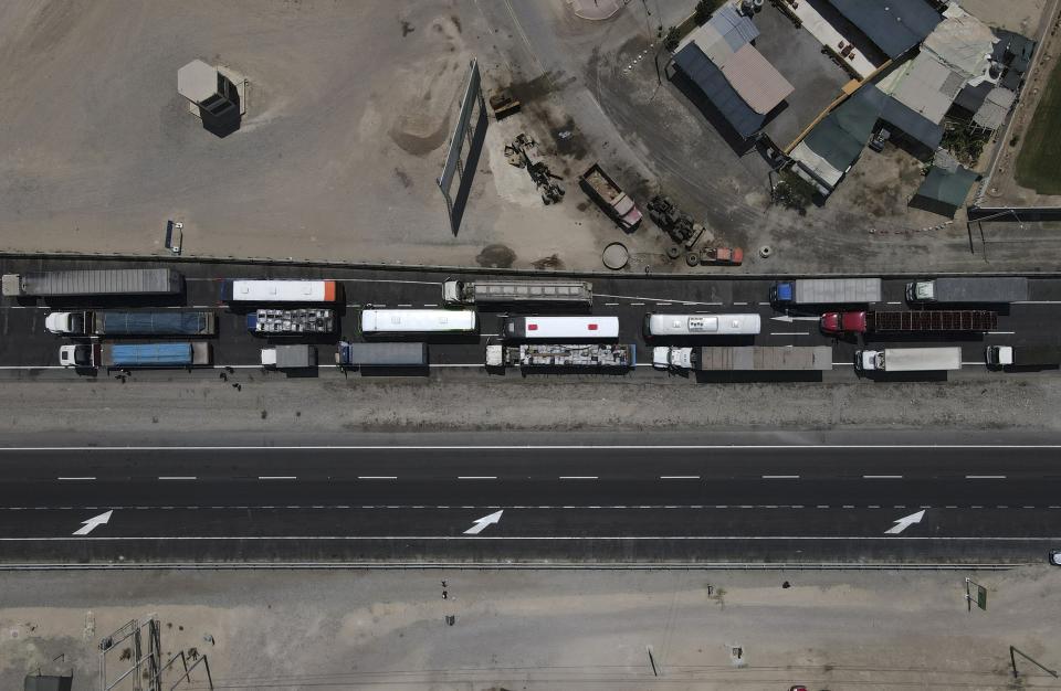 Truckers are backed up on the Pan-American highway because supporters of ousted Peruvian President Pedro Castillo are blocking it in protest of his detention, in Ica, Peru, Tuesday, Dec. 13, 2022. Castillo said Tuesday he is being "unjustly and arbitrarily detained" and thanked his supporters for their "effort and fight" since he was taken into custody last week. (AP Photo/Martin Mejia)