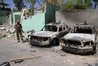 FILE PHOTO: A member of the Afghan security forces stands guard next to damaged army vehicles after a Taliban attack in Ghazni city, Afghanistan, August 15, 2018. REUTERS/Mustafa Andaleb/File Photo