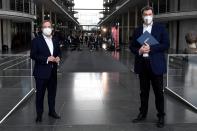 The chairman of the German Christian Democratic Party (CDU), ArminLaschet, left, and the chairman of the German Christian Social Union (CSU), Markus Soeder, right, after a statement folowing a closed meeting of the federal parliament factions of both partys in Berlin, Germany, Sunday, April 11, 2021. The two party chairmen and German state governors want to become the center-right candidate for the country's Sept. 26 national election, the German news agency dpa reported Sunday. (Tobias Schwarz/Pool Photo via AP)