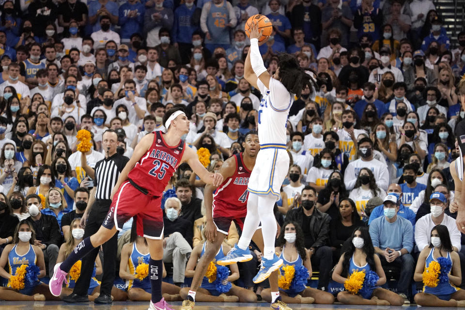 UCLA guard Tyger Campbell, right, shoots as Arizona guard Kerr Kriisa, left, and guard Dalen Terry defend during the first half of an NCAA college basketball game Tuesday, Jan. 25, 2022, in Los Angeles. (AP Photo/Mark J. Terrill)