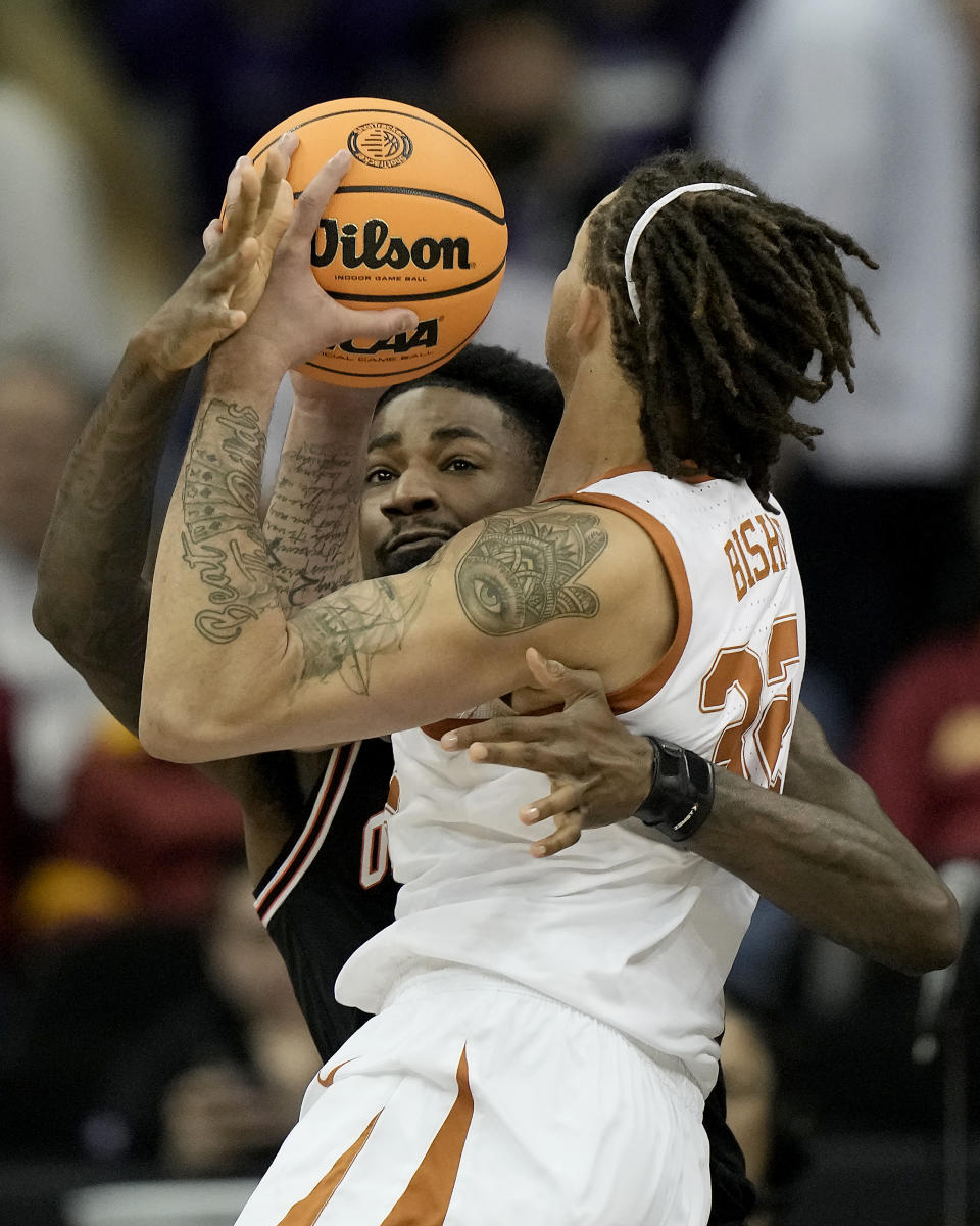 Oklahoma State forward Kalib Boone, back, tries to steal the ball from Texas forward Christian Bishop during the first half of an NCAA college basketball game in the second round of the Big 12 Conference tournament Thursday, March 9, 2023, in Kansas City, Mo. (AP Photo/Charlie Riedel)