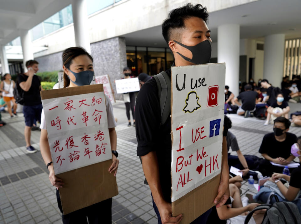 People hold signs during a demonstration by students and others at Edinburgh Place in Hong Kong, Thursday, Aug. 22, 2019. High school students thronged a square in downtown Hong Kong Thursday to debate political reforms as residents gird for further anti-government protests. (AP Photo/Vincent Yu)