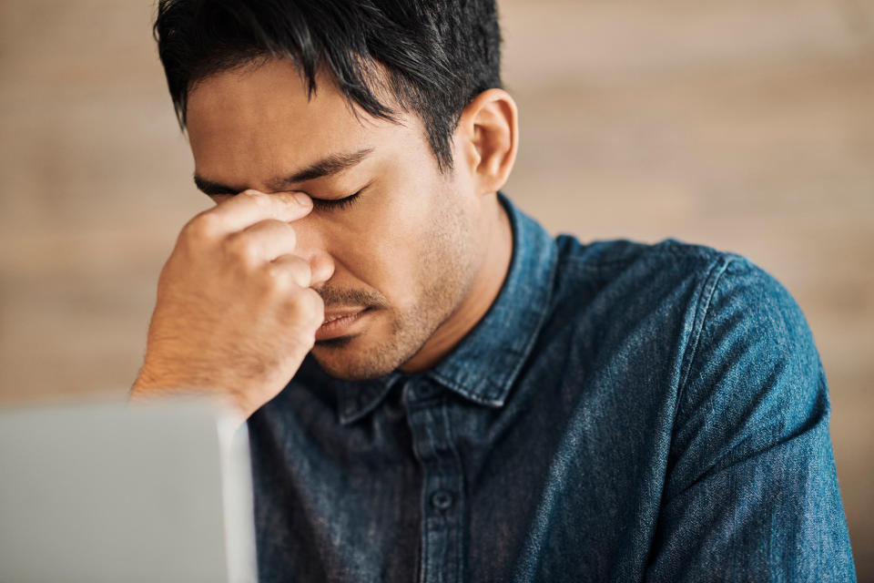 A man looking stressed at his computer