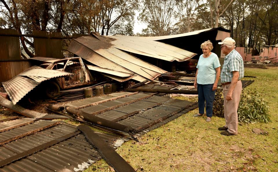 Art Murphy (R) and his wife Shirley look at a burnt-out section of their property which was caught in bushfires in Old Bar, 350km north of Sydney on November 11, 2019. A state of emergency on November 11 was declared and residents in the Sydney area were warned of "catastrophic" fire danger as Australia girded for a fresh wave of deadly bushfires that have ravaged the drought-stricken east of the country. (Photo by PETER PARKS / AFP) (Photo by PETER PARKS/AFP via Getty Images)