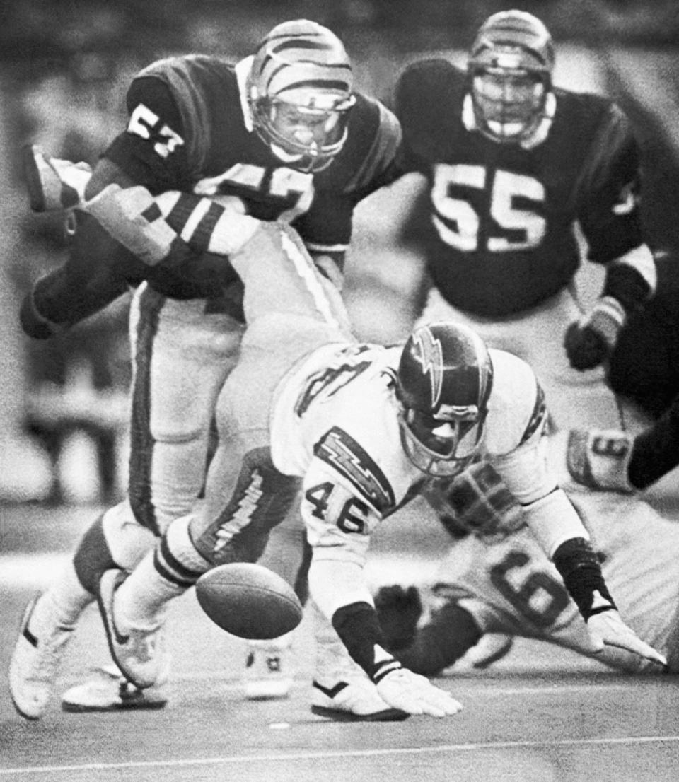 San Diego Chargers running back Chuck Muncie (46) loses the football as he is pounded by Cincinnati Bengals linebacker Reggie Williams during third quarter action of the AFC championship in Cincinnati on Jan. 10, 1982.